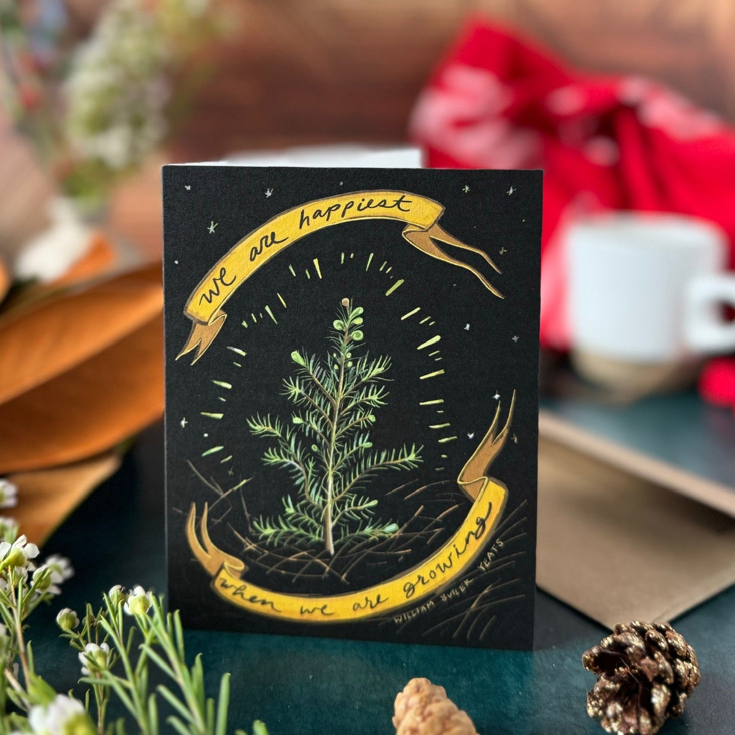 Decorative card with greenery and text on a wooden surface with a blurred background