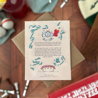 Greeting card back with embroidery detail with decorative elements on a wooden surface