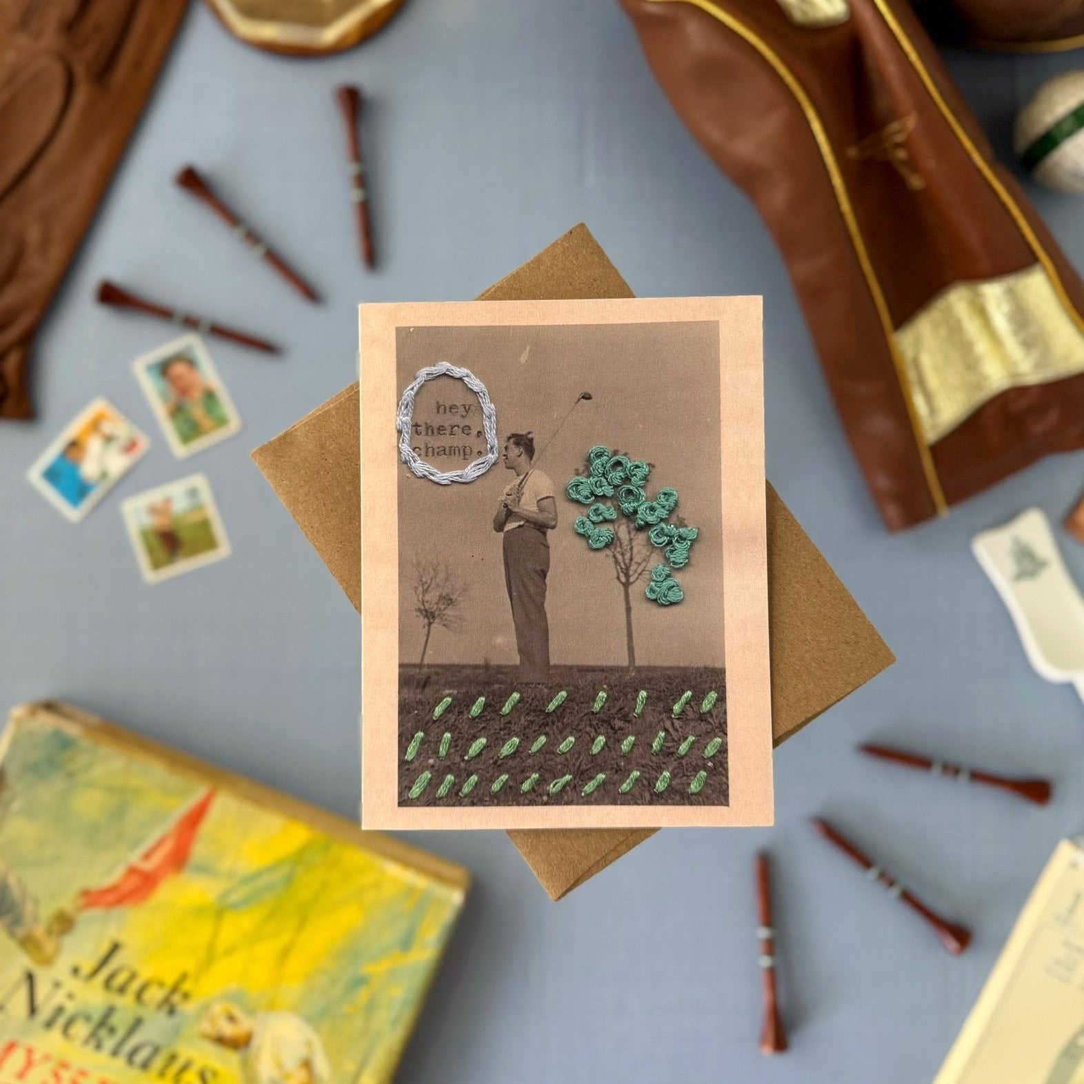 Vintage-style card with a person golfing, surrounded by books and gloves on a gray surface.