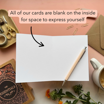 Blank card with pen and stationery items on a pink background